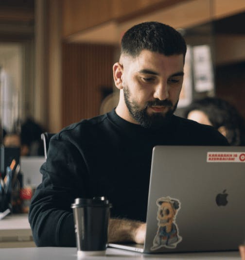 Photo of a man on his laptop managing his purchase payments