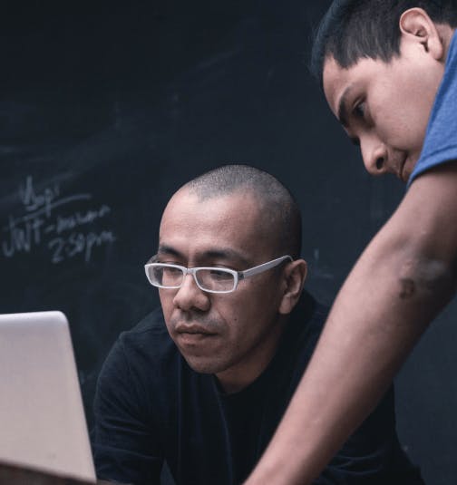 Photo of two men looking at their screen
